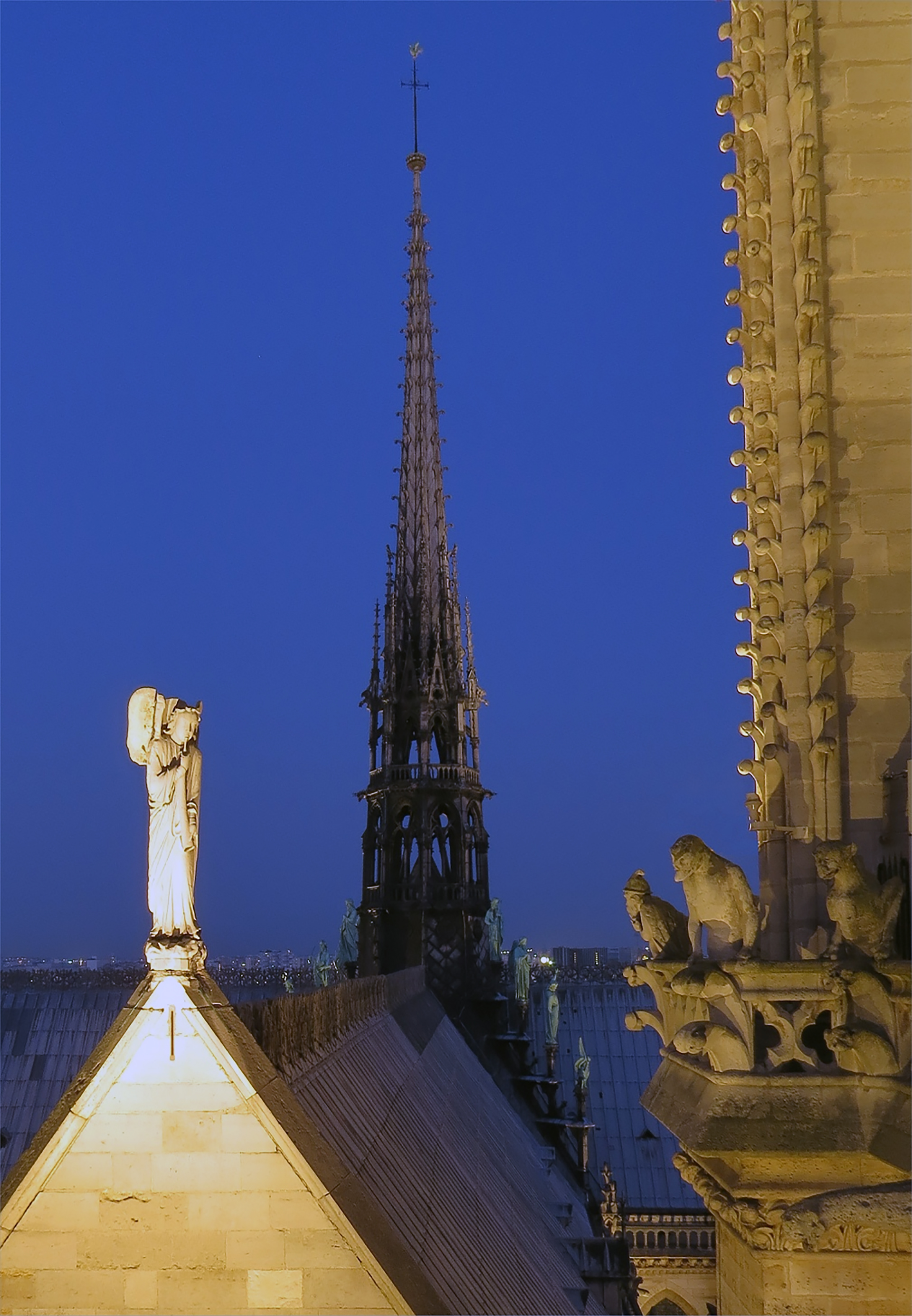 notre dame cathedral and the spire of viollet the duke, completed in 1859. in the foreground, the angel of the apocalypse and the alchemist philosopher.